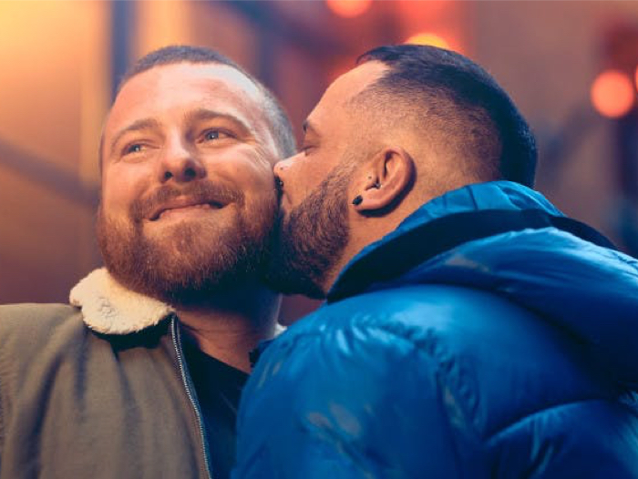 man giving another man kiss on cheek 