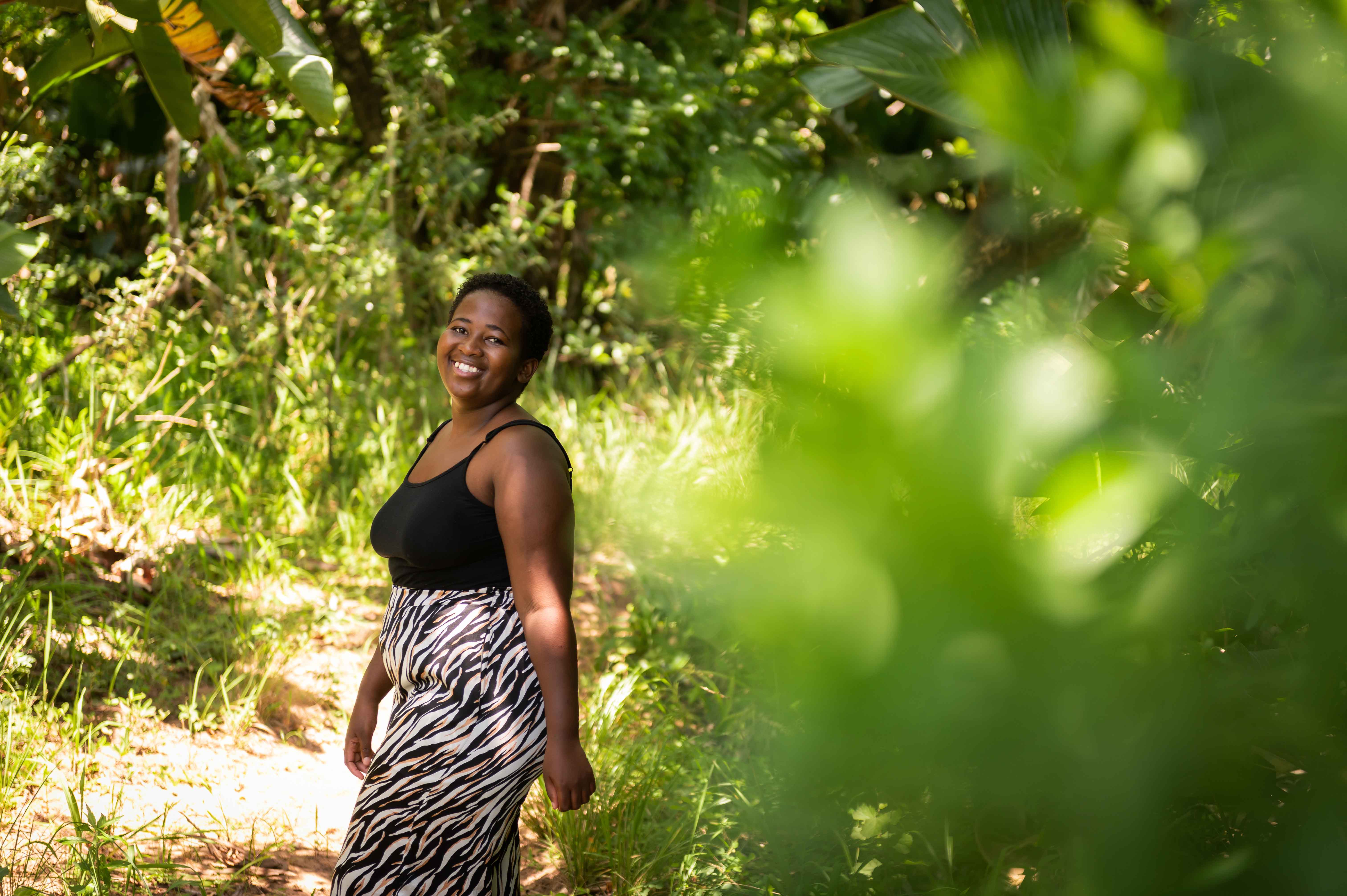 A young woman living with HIV smiling, outside